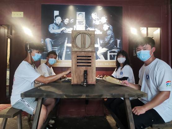 说明: F:\8 桂林航天工业学院\4 办公室工作\大创、挑战杯、社会实践\桂林航天工业学院+移动博物馆赋能党史学习教育+实践团\三下乡--铭记革命历史,传承红色文化,推进党史学习\实践团成员在讲解员的指导下体验电报机.jpg